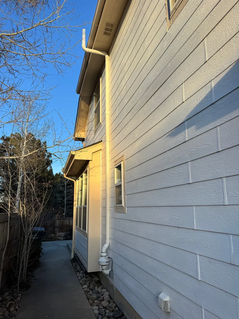 Finished radon system running up the side of a two-story Colorado home