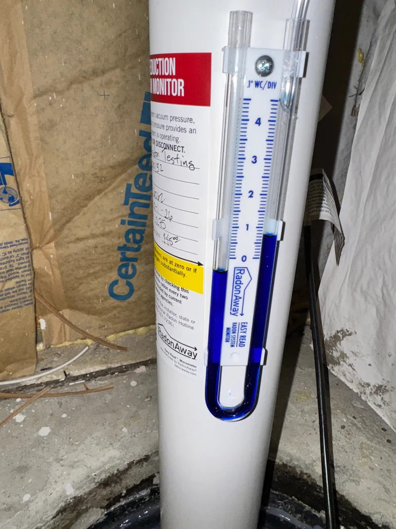 U-tube manometer on a radon pipe showing the system is pulling a vacuum